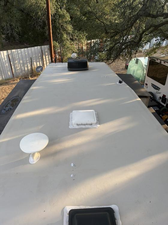 An RV roof with the vent refitted and the surface prepared for coating