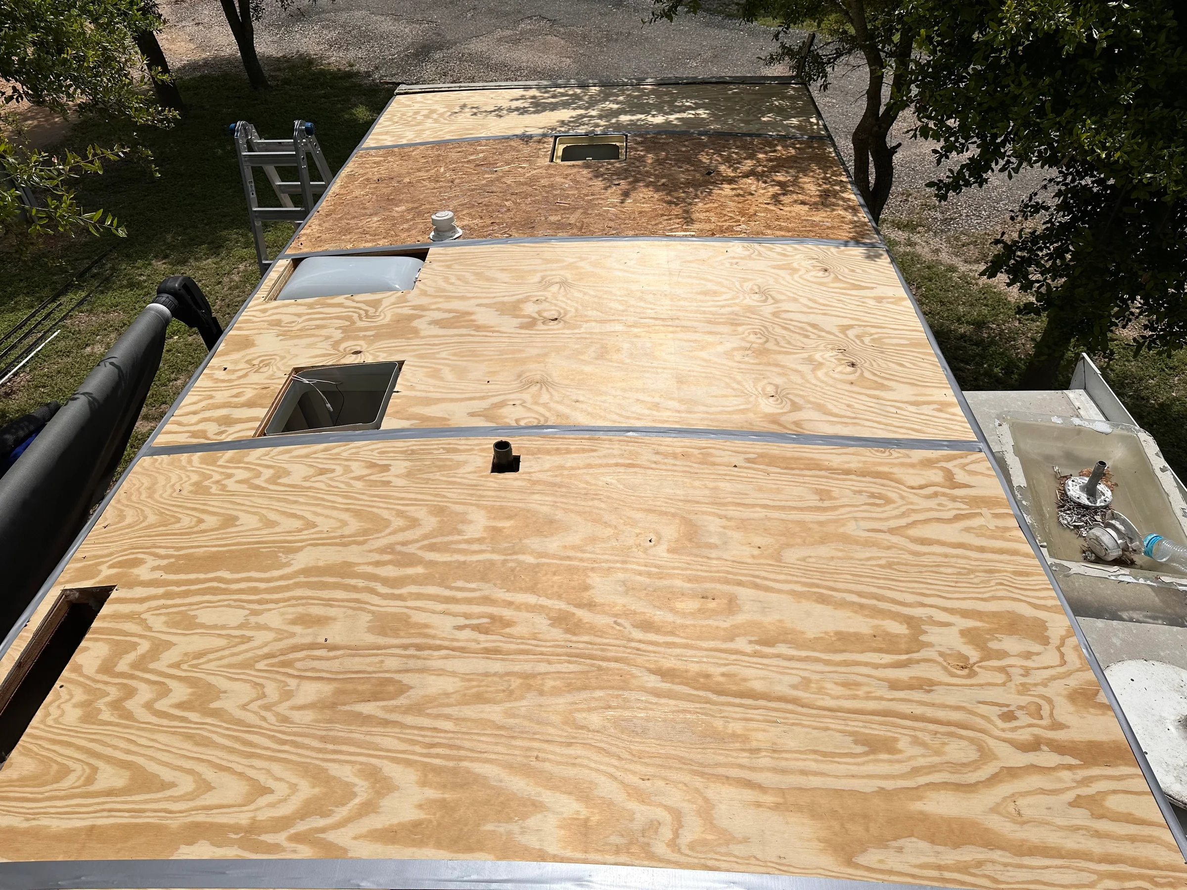 RV roof replacement in progress showing new plywood decking installation